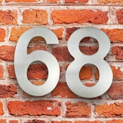 Número de casa moderno Wijher plateado 20 cm de acero inoxidable, número 68 en una fachada de ladrillo rojo